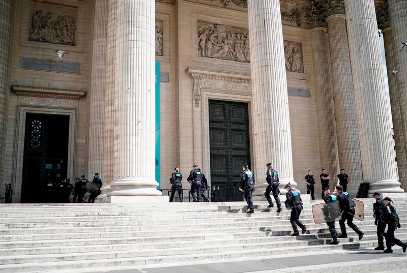 French police officers walk in Pantheon in Paris as undocumented migrants occupy the landmark to ask for the regularisation of their situation, on July 12, 2019. / AFP / Kenzo TRIBOUILLARD
