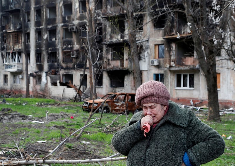 Tamara, 71, cries in front of a destroyed apartment building in Mariupol. Reuters
