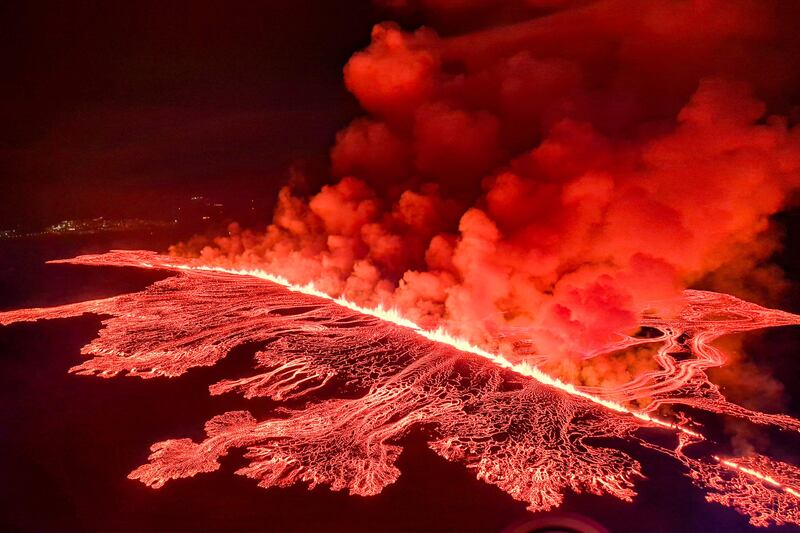 Billowing smoke and flowing lava pours out of a new fissure as a volcano erupts on the outskirts of Grindavik, western Iceland. AFP
