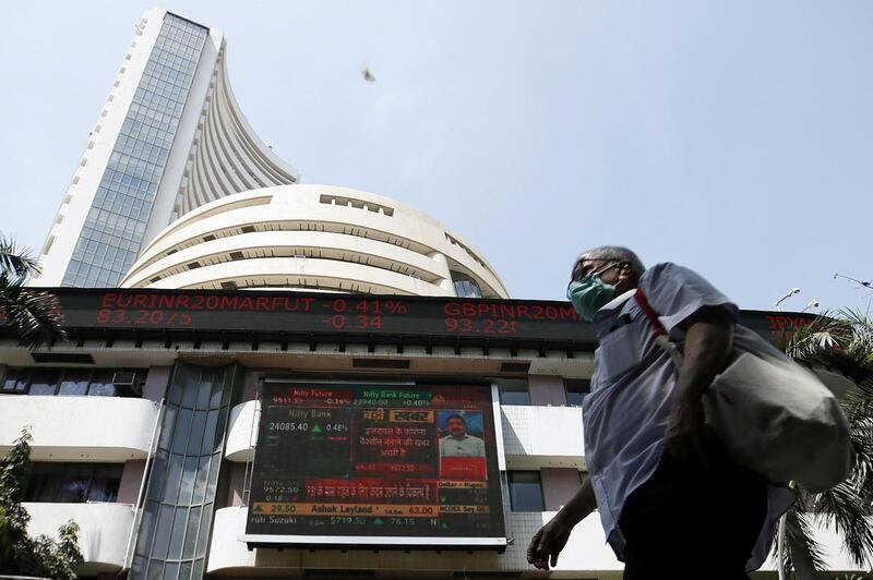 FILE PHOTO: A man wearing a protective mask walks past the Bombay Stock Exchange (BSE) building in Mumbai, India, March 13, 2020. REUTERS/Francis Mascarenhas/File Photo