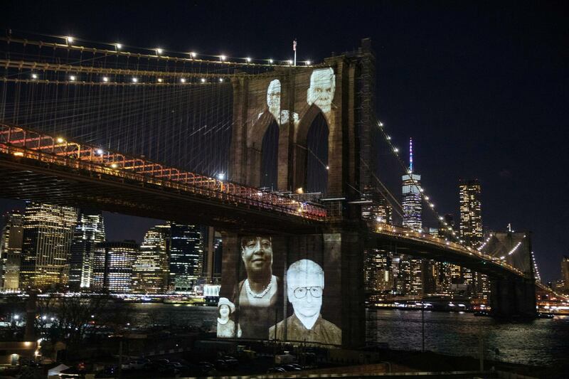 New Yorkers who passed during the COVID-19 pandemic are projected onto the Brooklyn Bridge in Brooklyn, New York, U.S. March 14, 2021. Kevin Hagen/Pool via REUTERS