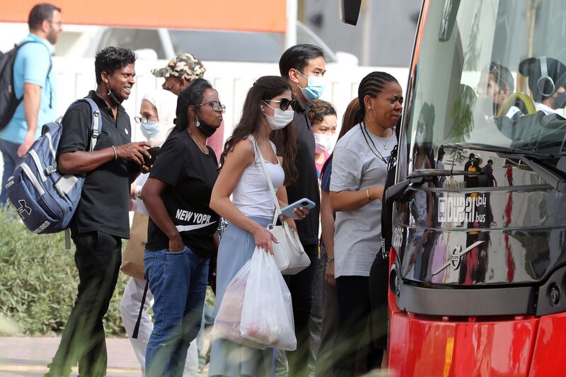 People wearing protective face mask at the bus station in Barsha Heights, Dubai.  Pawan Singh / The National