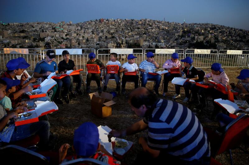 A group of orphans from the northern city of Irbid break their fast after watching the firing of the cannon to announce the breaking of the fast at Amman, Jordan. REUTERS