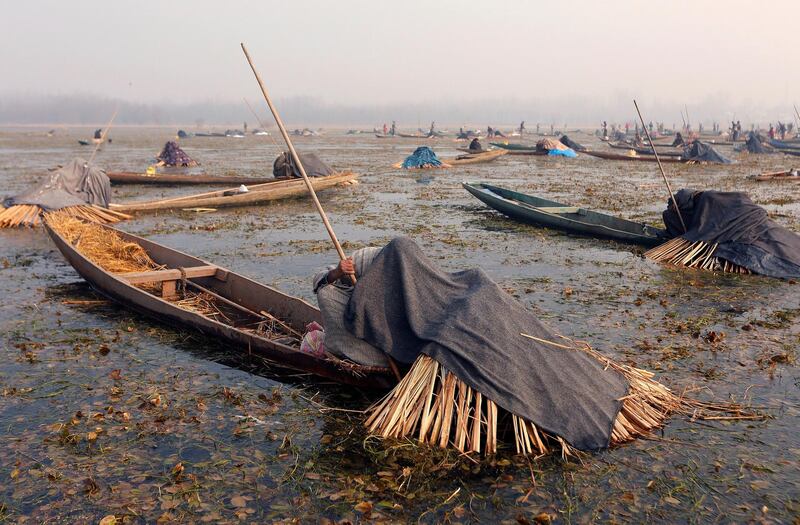 Fishermen cover their heads and part of their boats with blankets and straw as they wait to catch fish in the waters of the Anchar Lake on a cold winter day in Srinagar. Danish Ismail / Reuters