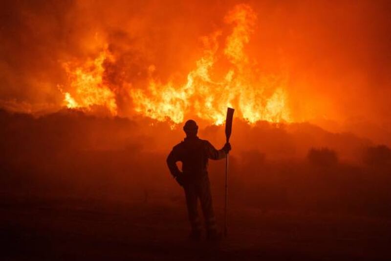 Firefighters operate at the site of a wildfire between Navalacruz and Riofrio near Avila, central Spain.