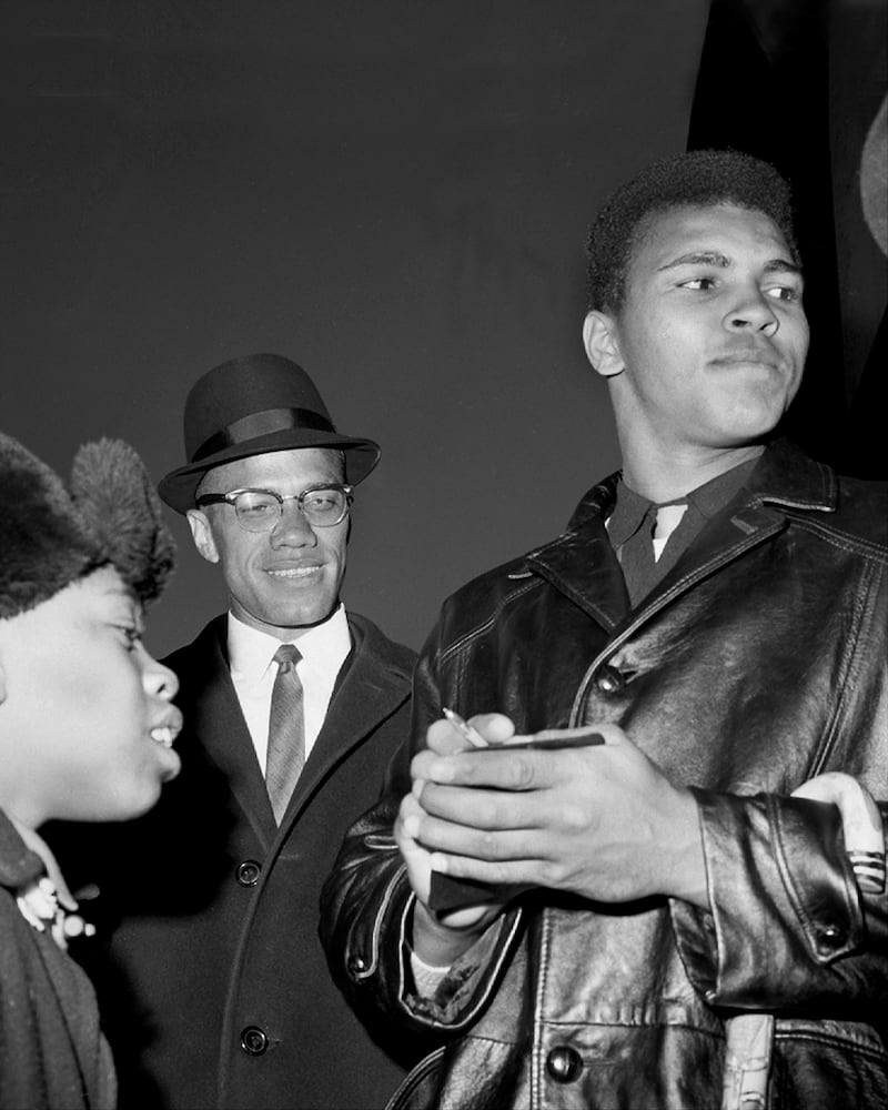 Ali signs an autograph alongside US civil rights leader Malcolm X. Getty