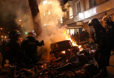 French riot police extinguish a fire amid clashes with protesters in Paris. Reuters