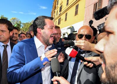 Italy’s Interior Minister and deputy PM Matteo Salvini (L) faces the press and residents during a visit to the San Lorenzo district of Rome on October 24, 2018 a week after a female teenager was found dead in a neighbourhood's building. - The body of sixteen-year-old Desiree Mariottini was found dead overnight on October 19 in a building in San Lorenzo, a death that could have happened following a rape. (Photo by Alberto PIZZOLI / AFP)