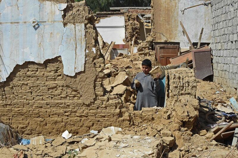 A boy stands amid the rubble of collapsed houses following an earthquake in the remote mountainous district of Harnai on October 7, 2021, as at least 20 people were killed and dozens injured when a shallow earthquake hit southwestern Pakistan in the early hours of October 7.  (Photo by Banaras KHAN  /  AFP)