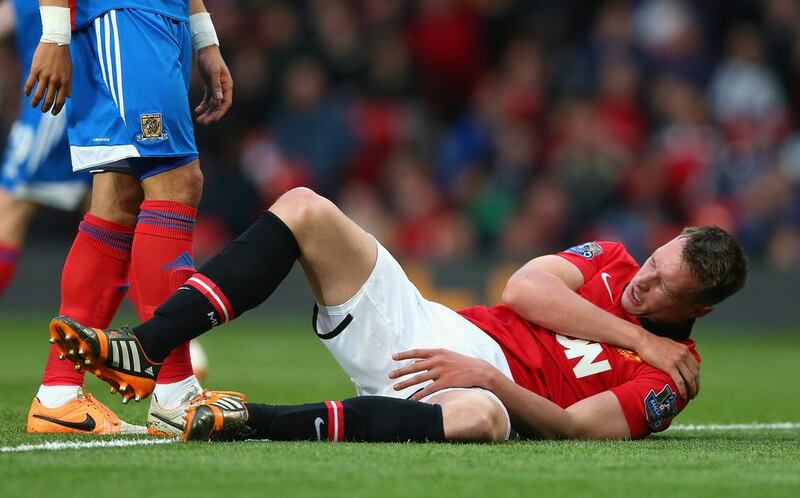 Phil Jones of Manchester United holds his shoulder after sustaining an injury in Tuesday's Premier League match against Hull City. Alex Livesey / Getty Images / May 6, 2014
