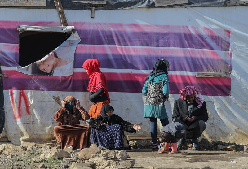 Syrian refugee families sit in the sun in front of their tents in Gazza village in the Beqaa valley, Lebanon. EPA