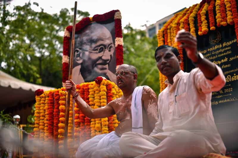 Anand Bhowmick, 57, dressed up as Gandhi, sits in front of a portrait of the Indian independence leader in Chennai. EPA
