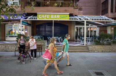 Pedestrians walk past a shuttered cafe bar in Salou, Spain, on Monday, July 27, 2020. Spain's tourism industry is at increasing risk of being shut down as countries across Europe seek to restrict visits to the Mediterranean nation, following an order by the British government to quarantine visitors. Photographer: Angel Garcia/Bloomberg