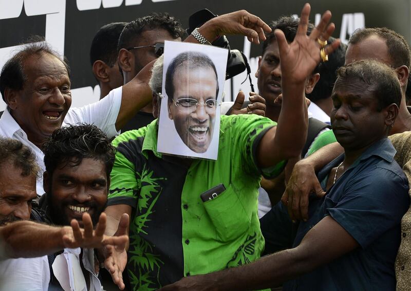 (FILES) In this file photo taken on November 15, 2018, a supporter of Sri Lanka's ousted prime minister Ranil Wickremesinghe wears a mask depicting Sri Lankan President Maithripala Sirisena during a rally in Colombo. Sri Lanka's President Maithripala Sirisena on November 18, 2018 called crucial talks with political leaders in a bid to end a power struggle with the prime minister he sacked last month.
 / AFP / LAKRUWAN WANNIARACHCHI
