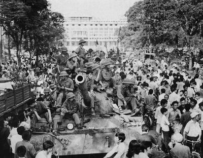 Local residents crowd North Vietnamese Army tanks taking position near the presidential palace in Saigon on April 30, 1975. AFP
