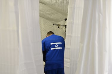 A medical member gives a treatment to a patient at Israeli field hospital, in Mostyska near the Polish border, in Lviv, western Ukraine, on March 23, 2022.  - Israeli field hospital provide assistance to migrants and residents of Lviv.  (Photo by Yuriy Dyachyshyn  /  AFP)