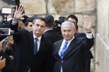 Brazilian President Jair Bolsonaro (L) and Israeli Prime Minister Benjamin Netanyahu wave to the press during a visit to the Western wall, the holiest site where Jews can pray, in the Old City of Jerusalem on April 1, 2019. AFP