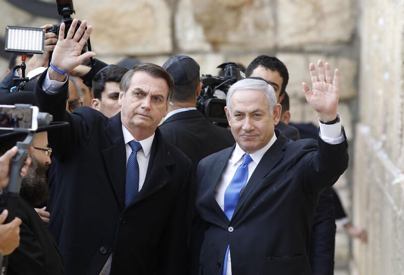 TOPSHOT - Brazilian President Jair Bolsonaro (L) and Israeli Prime Minister Benjamin Netanyahu wave to the press during a visit to the Western wall, the holiest site where Jews can pray, in the Old City of  Jerusalem on April 1, 2019. Bolsonaro arrived in Israel just ahead of the country's polls in which his ally Prime Minister Benjamin Netanyahu faces a tough re-election fight. / AFP / POOL / Menahem KAHANA
