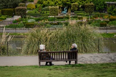 Two women keep their distance as they chat on a bench in Golders Hill Park, London, on May 13, 2020. Getty Images