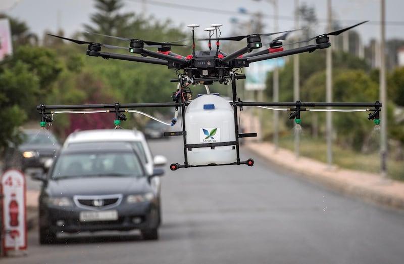 A drone equipped with disinfectant liquid, operated by a Moroccan startup company, is flown above a street of Harhoura near the capital Rabat on April 23, 2020, to be used during the novel coronavirus pandemic crisis. / AFP / FADEL SENNA
