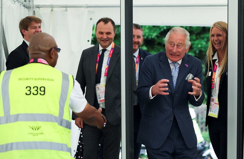 Prince Charles reacts as he sets off a metal detector during a visit to the Athletes Village. AP