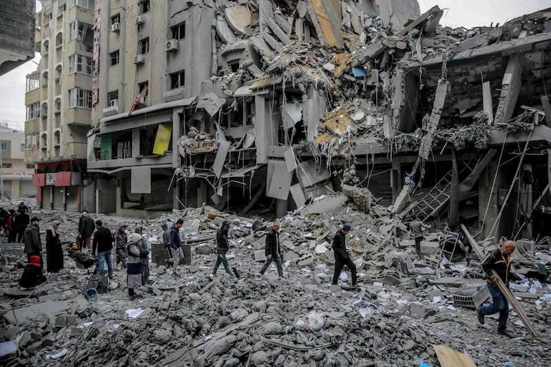 Palestinians walk amid the rubble of houses destroyed by the Israeli bombardment of Gaza city. AFP