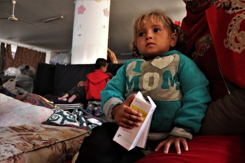 A little girl sits on her mother's lap inside the mosque after leaving their home. EPA