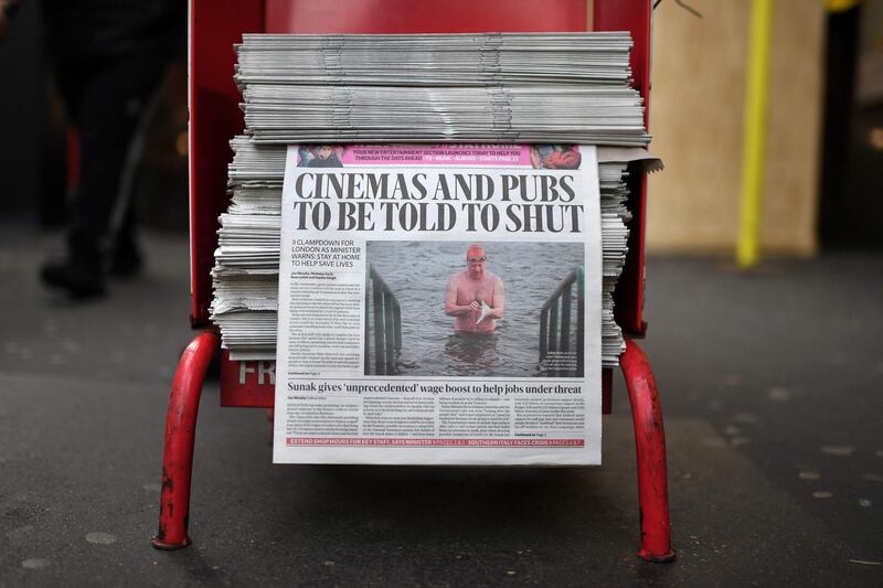 The front page of the Evening Standard newspaper, leading with the story that UK cinemas and pubs are likely to be ordered close later today, is pictured in London on March 20, 2020, during the ongoing coronavirus pandemic. Britain's Prime Minister Boris Johnson on Thursday said he was confident the country can slow the spread of coronavirus in the next three months through tough measures to cut social contact. The government earlier this week called for more people to work from home, and avoid public transport, pubs, clubs and restaurants, to try to slow infection rates. / AFP / DANIEL LEAL-OLIVAS
