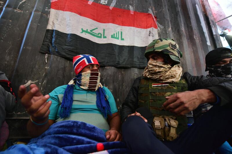 Protesters speak to each other as they sit on the Al Sinak bridge. EPA