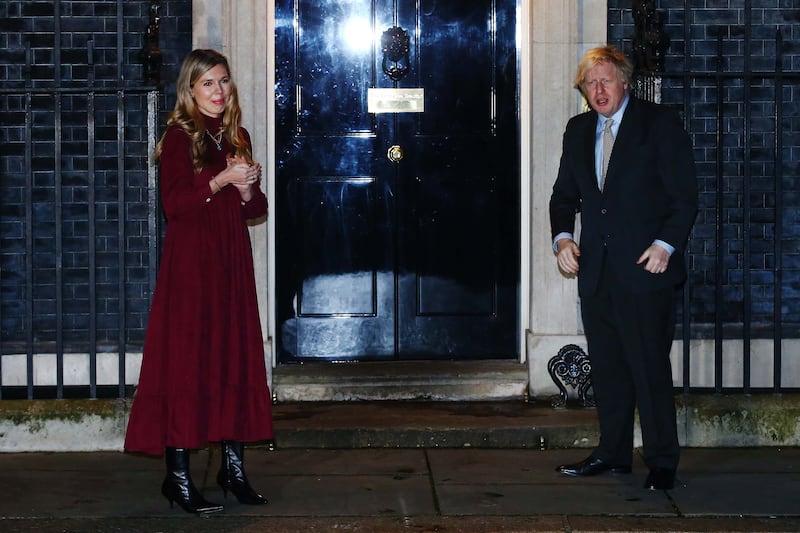 Mr Johnson and his fiancee Carrie Symonds take part in a doorstep clap in memory of Captain Sir Tom Moore outside 10 Downing Street on February 3.
