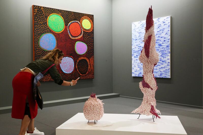 A woman takes a photo of Japanese artist Yayoi Kusama's 2018 piece "Flower" at Arab Dubai in Dubai. AP Photo