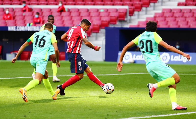 Luis Suarez shoots to score Atletico's sixth goal against Granada. Reuters