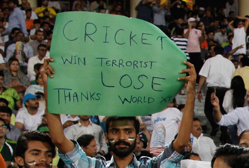 A Pakistani cricket fan holds a placard during a final of Twenty20 International match between World XI and Pakistan at Gaddafi stadium in Lahore, Pakistan, Friday, Sept. 15, 2017. The series is aimed at reviving international cricket in Pakistan, since terrorists attacked the Sri Lanka cricket team bus in Lahore in 2009. (AP Photo/K.M. Chaudary)