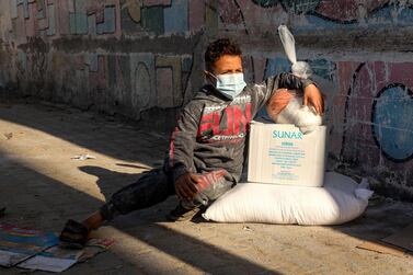 A masked child sits next to packs of humanitarian aid in Gaza City. The Covid-19 crisis has profoundly affected employment in an already faltering Palestinian economy, the World Bank said. AFP