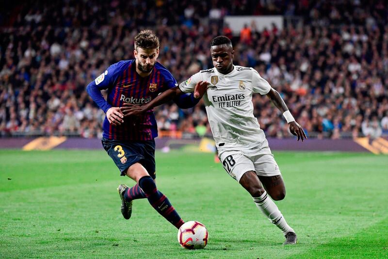 Real Madrid forward Vinicius Junior challenges Barcelona's defender Gerard Pique. AFP