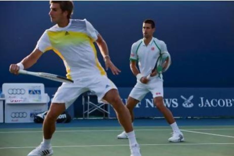 Marko Djokovic, front, and his older brother Novak won their first set as a doubles pair yesterday against Nicolay Davydenko and Dick Norman but lost their match 6-4, 3-6, 10-4. Antonie Robertson / The National