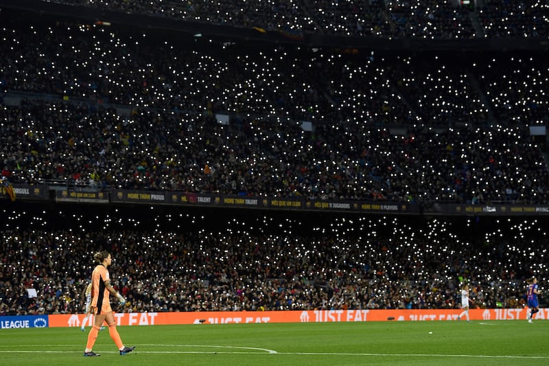Supporters hold up their smartphone flashes during the match. AFP