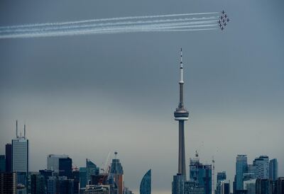 The Canadian Snowbirds circle the CN Tower as part of Operation Inspiration during the COVID-19 pandemic in Toronto, Sunday, May 10, 2020. (Nathan Denette/The Canadian Press via AP)