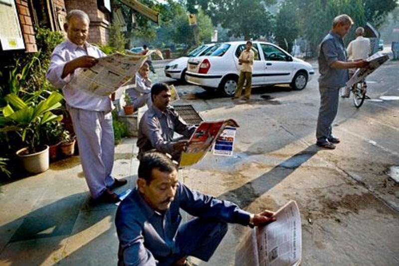 Taxi drivers read various local newspapers as they wait for business in the taxi station at the Defence Colony market early in the morning on 20th October 2008 in New Delhi, India. With internet still out of reach for 95% of the country and literacy higher than ever, more and more are turning to newspapers and magazines.  Photo : Suzanne Lee for The National.