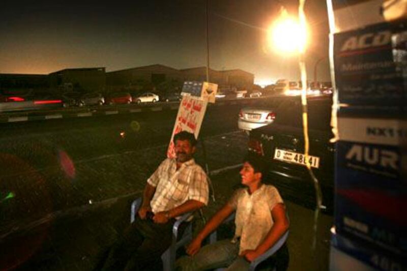 AL SHARJAH - AUGUST 20,2009 - People in Sharjah Industrial area 1 stay outside their house and use car batteries to lit their place after several parts of Industrial Area 1 turned into darkness caused by sudden major breakdown of electricity plant  suplying the affected areas ( Paulo Vecina/The National )