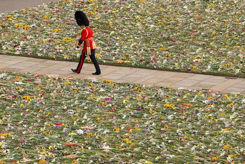 A member of the Coldstream Guards walks past flowers at St George's Chapel in Windsor Castle. AP