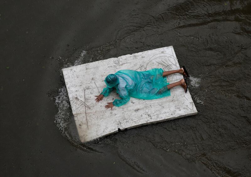 A boy floats on a polystyrene sheet in Mumbai, India. AP Photo