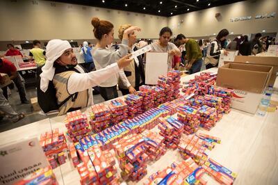 Volunteers pack essentials at the Bridges of Goodness event at Expo City, Dubai. Leslie Pableo for The National