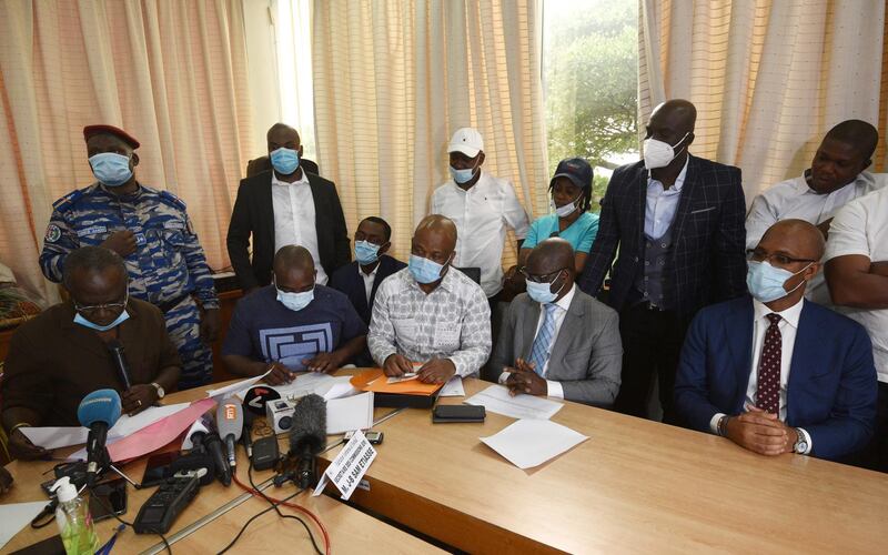 Former Ivorian forward Didier Drogba (R) wearing a mask, listens to Ivorian Football Federation's secretary Jean-Baptiste Sam Etiasse (L). AFP