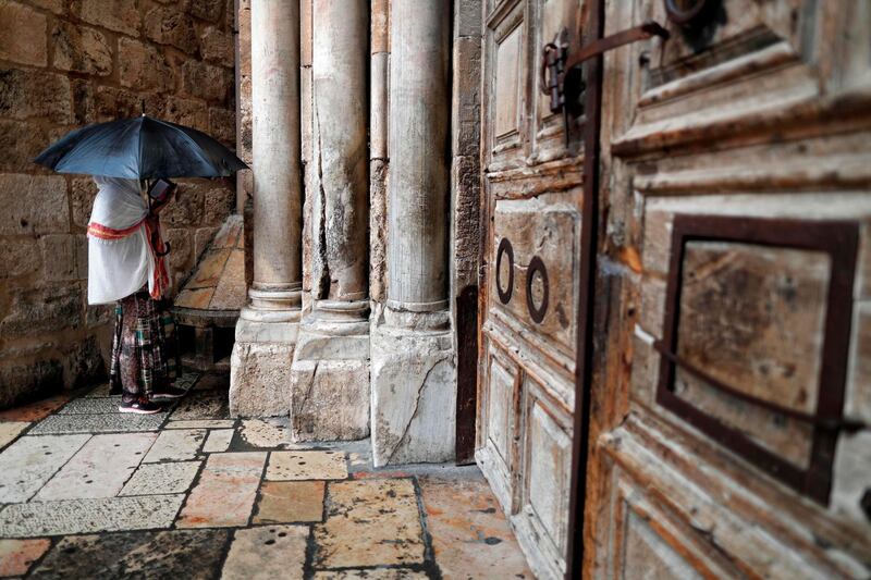 A Christian woman prays by the closed door of the main entrance of the Church of the Holy Sepulchre in the Old City of Jerusalem on February 26, 2018 after Christian leaders took the rare step of closing the church, seen as the holiest site in Christianity, the previous day at noon.
Jerusalem's Church of the Holy Sepulchre, built at the site where Christians believe Jesus was buried, remained closed today in protest at Israeli tax measures and a proposed property law.  / AFP PHOTO / THOMAS COEX