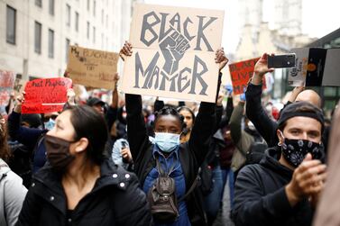 Demonstrators wearing protective face masks and face coverings hold placards as they march to the Home Office during a Black Lives Matter protest in London Reuters
