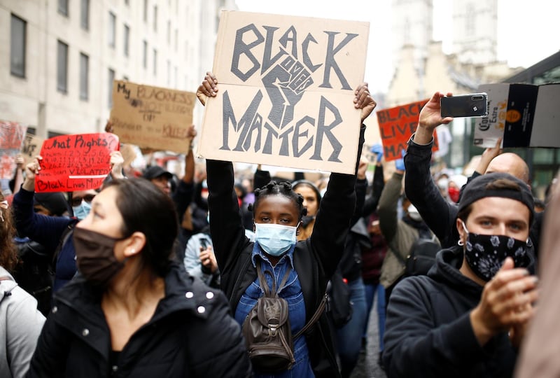 Demonstrators wearing protective face masks and face coverings hold placards as they march to the Home Office during a Black Lives Matter protest in London, following the death of George Floyd who died in police custody in Minneapolis, London, Britain, June 6, 2020. REUTERS/Henry Nicholls