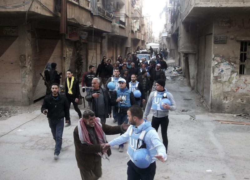 UN members walk along a street at the Palestinian refugee camp of Yarmouk, in southern Damascus. Reuters (24 February)