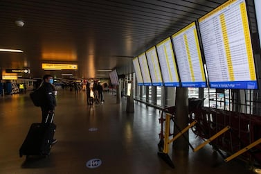 A traveller wearing a face mask checks the flight times at Schiphol Airport, near Amsterdam. AP