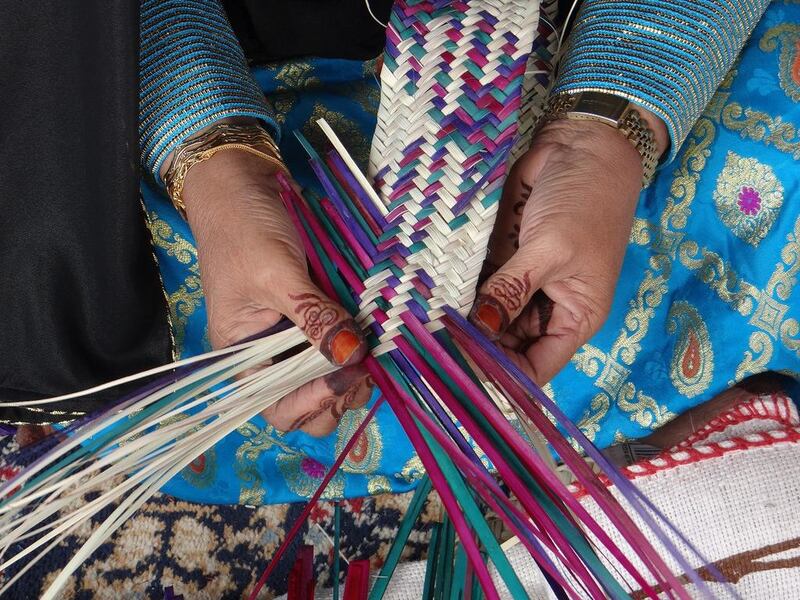 An Emirati woman weaves a basket at the Tan-Tan Moussem Festival in Morocco. Courtesy TCA
